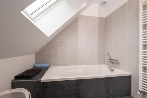 a bathroom with a bath tub with a skylight at Grande maison bord de Mer in Sarzeau