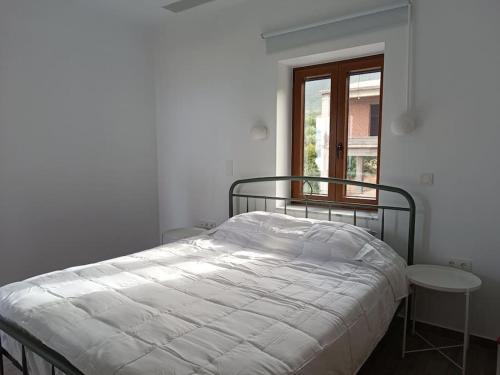 a white bed in a bedroom with a window at Anamesa Apartment 1 in Poúlithra