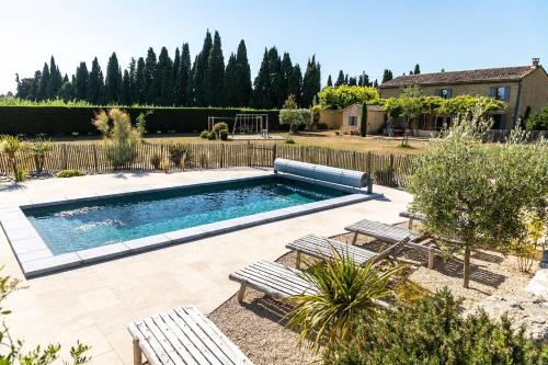 - une piscine dans une cour avec deux bancs dans l'établissement sous la glycine de costebelle, à Cheval-Blanc