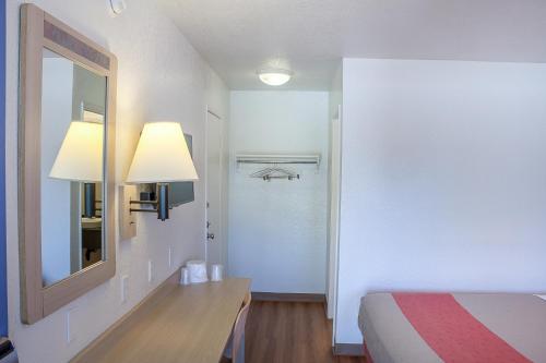 a bedroom with a bed and a mirror and a table at Motel 6-Ukiah, CA in Ukiah
