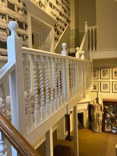 a staircase in a home with a white stair case at Langtry Manor Hotel in Bournemouth