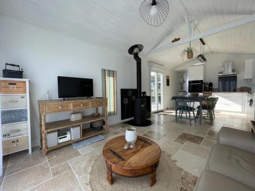 a living room with a couch and a table at TI KAZ - Terrasse extérieure - 5mn Plage in Pleubian