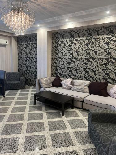 a living room with a couch and a patterned wall at David Apartment in Tbilisi City