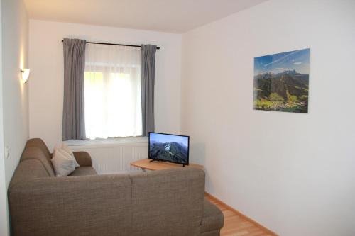 a living room with a couch and a laptop on a table at Apartments Gamsfeld in Russbach am Pass Gschütt
