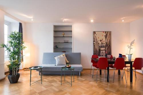 a living room with a blue couch and red chairs at HITrental Chapel Bridge Apartments in Luzern