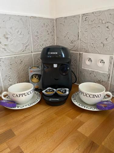 a coffee maker and two cups on a table at The Stable in Sourdeval