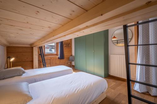 deux lits dans une chambre aux murs en bois dans l'établissement SmartStay Loft - Exterieur et vue Mont Blanc, à Chamonix-Mont-Blanc