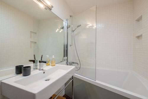 une salle de bain blanche avec un lavabo et une douche dans l'établissement SmartStay Loft - Exterieur et vue Mont Blanc, à Chamonix-Mont-Blanc