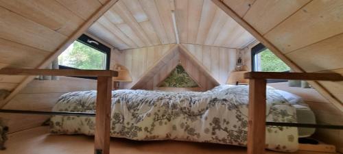 - une chambre dans une cabane dans les arbres avec un lit dans l'établissement Insolite Tiny House Sérénité Bien Être, à Ban-sur-Meurthe-Clefcy