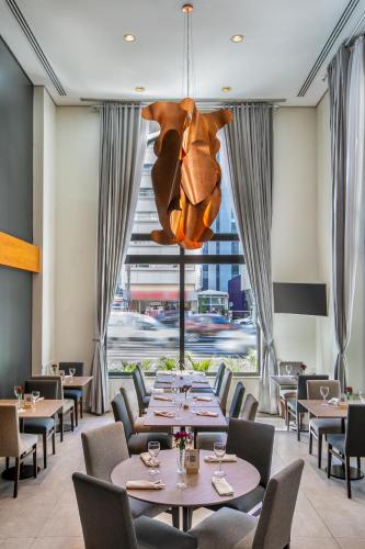 a restaurant with tables and chairs and a chandelier at Meliá Paulista in Sao Paulo