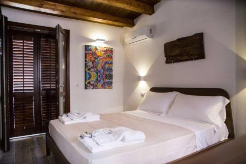 パレルモにあるCasa Vicolo San Giovanniのベッドとタオル2枚のある寝室