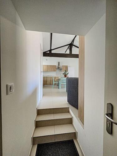 un couloir avec des escaliers menant à une cuisine et à une chambre dans l'établissement Agréable 3 chambres extra centre à 200m de l'océan, à Biscarrosse