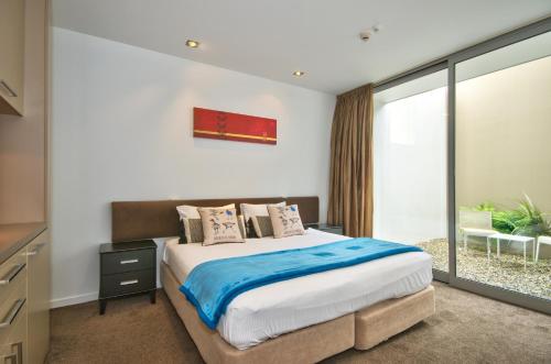 a bedroom with a bed and a large window at Charlies Queenstown Studio Apt 103B in Queenstown