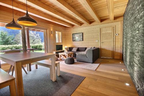 un salon avec une table et un canapé dans l'établissement Chalet Sirius, au Monêtier-les-Bains
