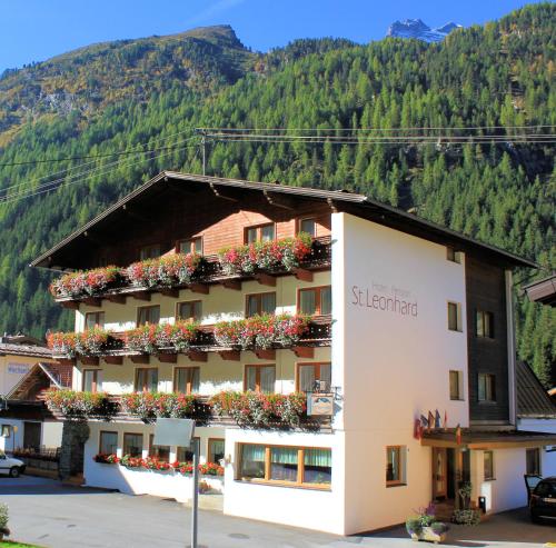 a hotel in the mountains with flowers on the windows at Hotel St-Leonhard in Sankt Leonhard im Pitztal