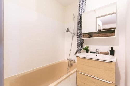une salle de bain avec un lavabo et une baignoire dans l'établissement Appartement T2 Hyper Centre RoLéo, à Saint-Lary-Soulan