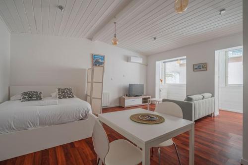 une chambre avec un lit, une table et un canapé dans l'établissement R'Apparts Petite Evasion, à Grenoble