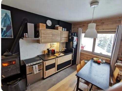 - une cuisine avec une cuisinière et une table dans une chambre dans l'établissement Ski au pied les Houches / Chamonix, aux Houches