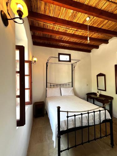 ein Schlafzimmer mit einem Bett und einer Holzdecke in der Unterkunft Kaizer Suites in Amargeti