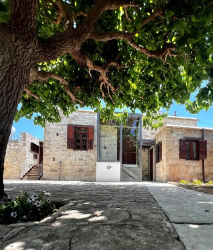 ein Backsteinhaus mit einer Tür unter einem Baum in der Unterkunft Kaizer Suites in Amargeti