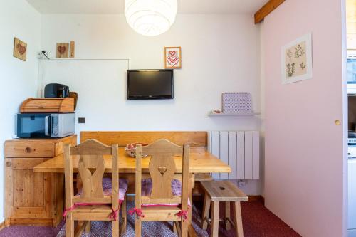 une salle à manger avec une table et des chaises en bois dans l'établissement Appartement Le Creux de l'Ours, à Les Allues