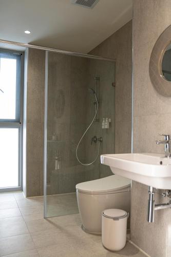 a bathroom with a shower and a toilet and a sink at Living In Light in Zhongpu