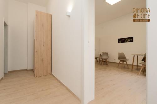 a room with a white wall and a wooden door at Dimora Fiume - locazione turistica B&B in Gorgofreddo