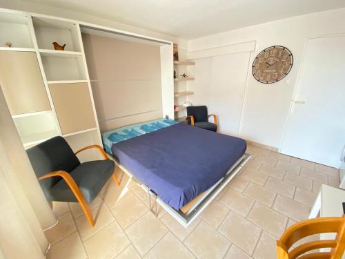une petite pièce avec un lit et une chaise dans l'établissement Bandol Appartement hyper centre terrasse et parking, à Bandol