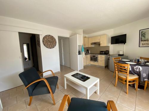 une cuisine et un salon avec une table et des chaises dans l'établissement Bandol Appartement hyper centre terrasse et parking, à Bandol