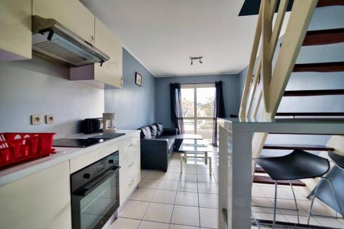 a kitchen with blue walls and white counter tops at F2en duplex tout équipé arrivée autonome in Noumea
