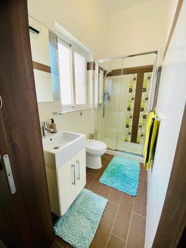 une salle de bain avec un lavabo, des toilettes et une douche dans l'établissement Spinola Shoreline Homestay St Julians, à San Ġiljan