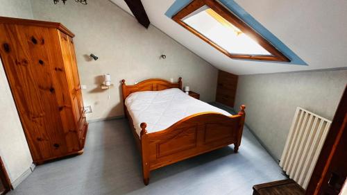 a bedroom with a wooden bed and a skylight at Aucairn in Château-Verdun