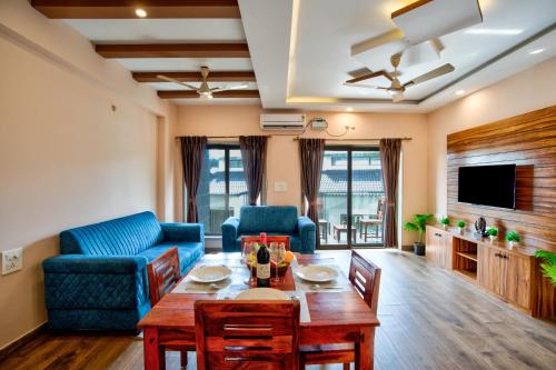 a living room with a table and a blue couch at Luxury 2BHK Apartment Near Candolim in Nerul