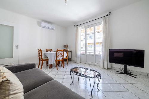 un salon avec un canapé et une table dans l'établissement LE CONNEMARRA avec balcon, lumineux et calme à côté du centre, à Cannes