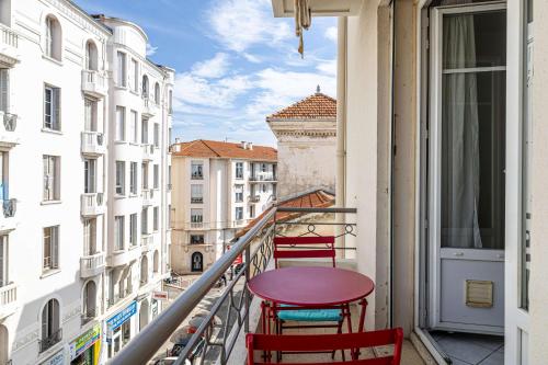 d'un balcon avec des chaises rouges et une table. dans l'établissement LE CONNEMARRA avec balcon, lumineux et calme à côté du centre, à Cannes