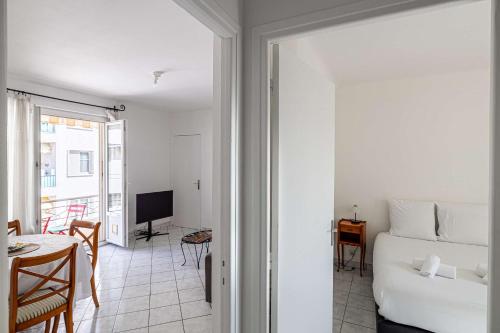 Cette chambre comprend un lit, une table et une télévision. dans l'établissement LE CONNEMARRA avec balcon, lumineux et calme à côté du centre, à Cannes