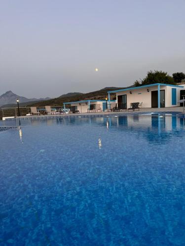 a large pool of blue water in front of a building at The Rocas Hotel in Kérynia