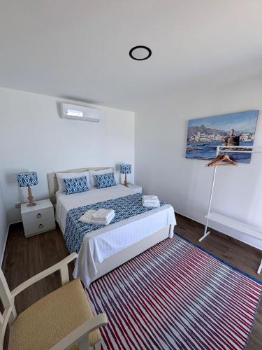 a bedroom with a bed and a chair and a rug at The Rocas Hotel in Kérynia