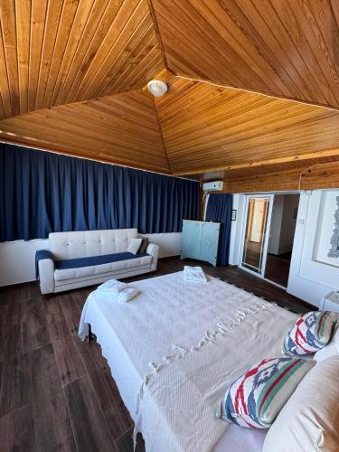 a large bedroom with a large bed and a couch at The Rocas Hotel in Kérynia
