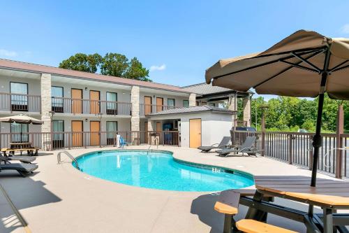 a swimming pool with a table and an umbrella at Quality Inn Commerce at I-85 in Commerce