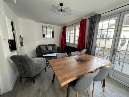ein Wohnzimmer mit einem Holztisch und Stühlen in der Unterkunft Dream house in Lille