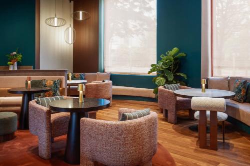 a restaurant with tables and chairs and a couch at Hotel Meliá Bilbao in Bilbao