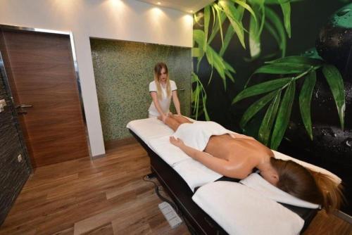 a woman is laying on a bed in a room at Spa Hotel Terme in Sarajevo
