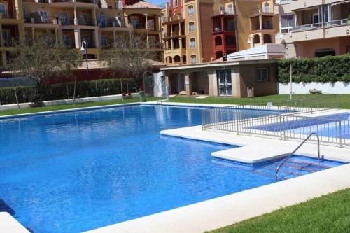 a large blue swimming pool in front of some buildings at Genial 1ª linea de mar Mediterráneo in Torrox