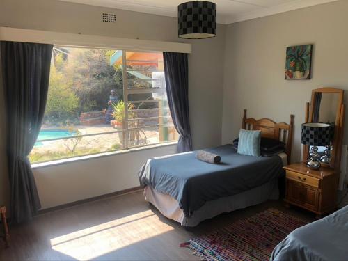 a bedroom with a bed and a large window at Schilbach House in Parys