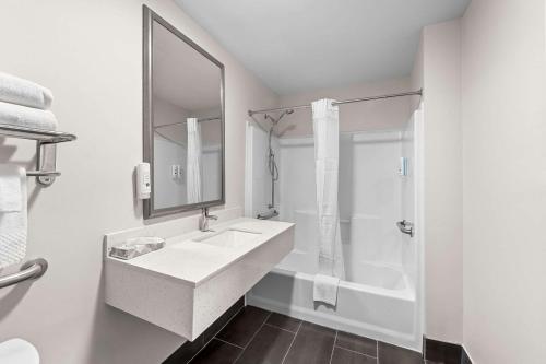 a white bathroom with a sink and a shower at Quality Inn & Suites Kilgore-Longview in Kilgore