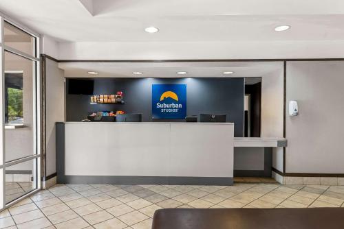 a lobby with a counter with a sign on the wall at Suburban Studios Orlando - Ocoee-Winter Garden in Orlando