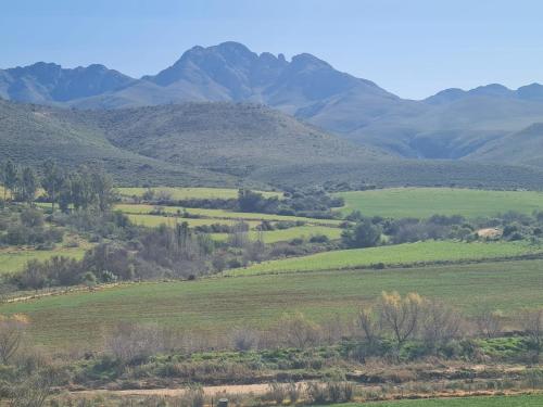 a view of a field with mountains in the background at Landsrivier Cottage No 1 in Uniondale
