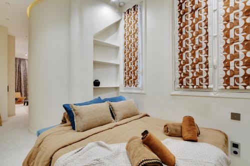 une chambre avec un grand lit avec des oreillers dessus dans l'établissement Le petit luxe parisien, à Paris