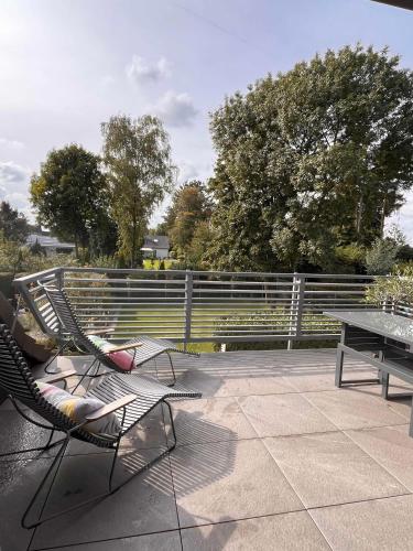 a patio with two chairs and a table and a fence at Ferienwohnung Kastanieneck in Kevelaer